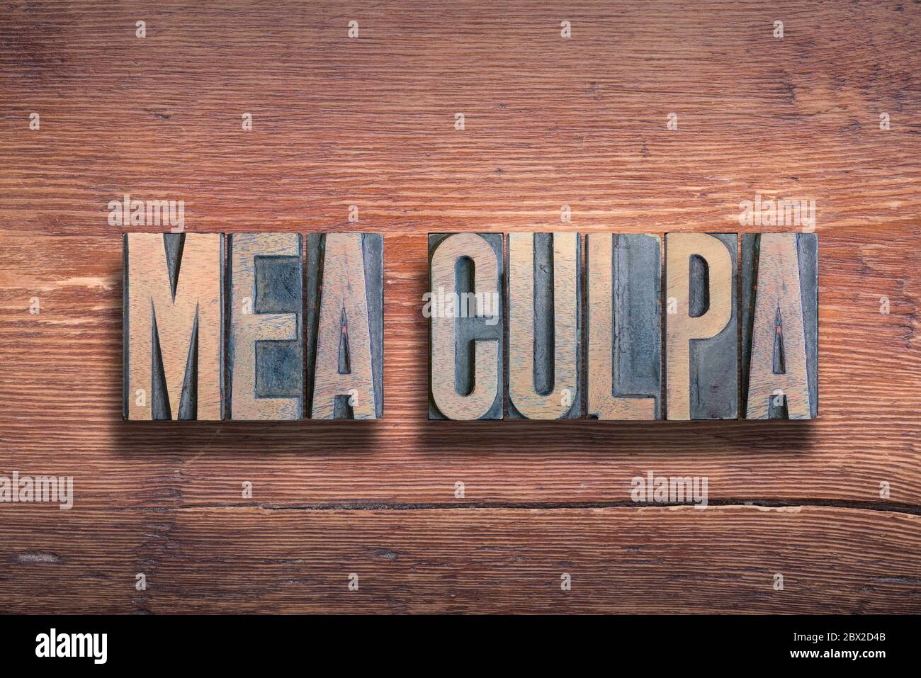 mea culpa ancient Latin saying meaning «through my fault» combined on vintage varnished wooden surface Stock Photo