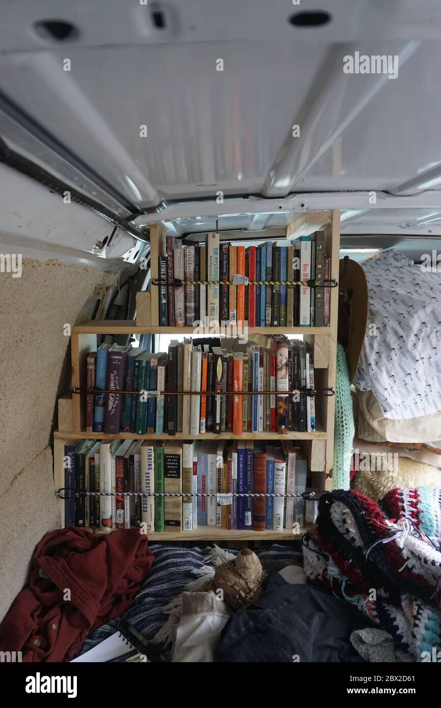 Van Life bookshelf that is handmade behind driver's seat. Colorado 2019