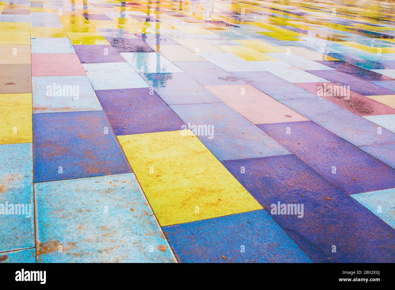 Colorful bright pavement - tar and concrete tiles with dye added - rain ...