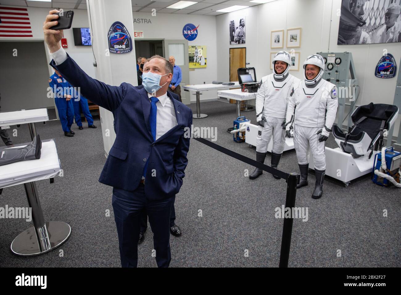 NASA Administrator Jim Bridenstine poses for a selfie with astronauts Robert Behnken, left, and Douglas Hurley, right, in their SpaceX spacesuits, after suiting up in the Neil Armstrong Operations and Checkout Building to Launch Complex 39A for the Demo-2 mission launch at the Kennedy Space Center May 30, 2020 Cape Canaveral, in Florida. The astronauts will make a second attempt at launch in the first commercial launch carrying astronauts to the International Space Station. Stock Photo