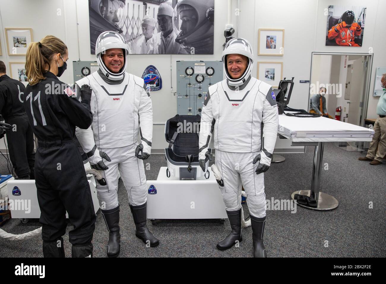 NASA astronauts Robert Behnken, left, and Douglas Hurley, right, are assisted with donning their SpaceX spacesuits, in the ready room of the Neil Armstrong Operations and Checkout Building to Launch Complex 39A for the Demo-2 mission launch at the Kennedy Space Center May 30, 2020 Cape Canaveral, in Florida. The astronauts will make a second attempt at launch in the first commercial launch carrying astronauts to the International Space Station. Stock Photo