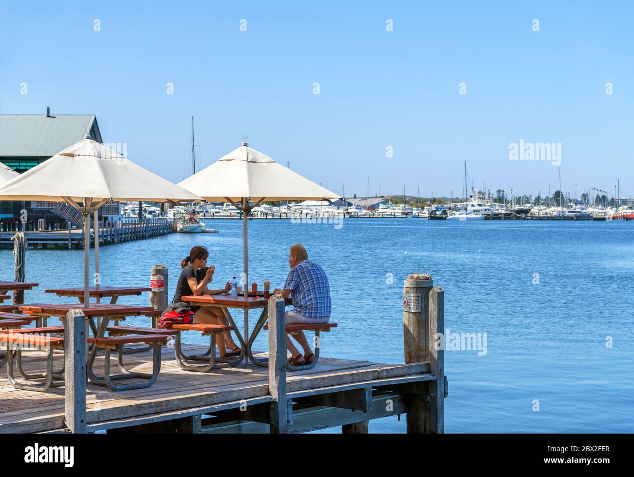 Couple sitting at a waterfront cafe / restaurant (Cicerello's), Fremantle Jetty, Fishing Boat Harbour, Fremantle, Western Australia, Australia Stock Photo