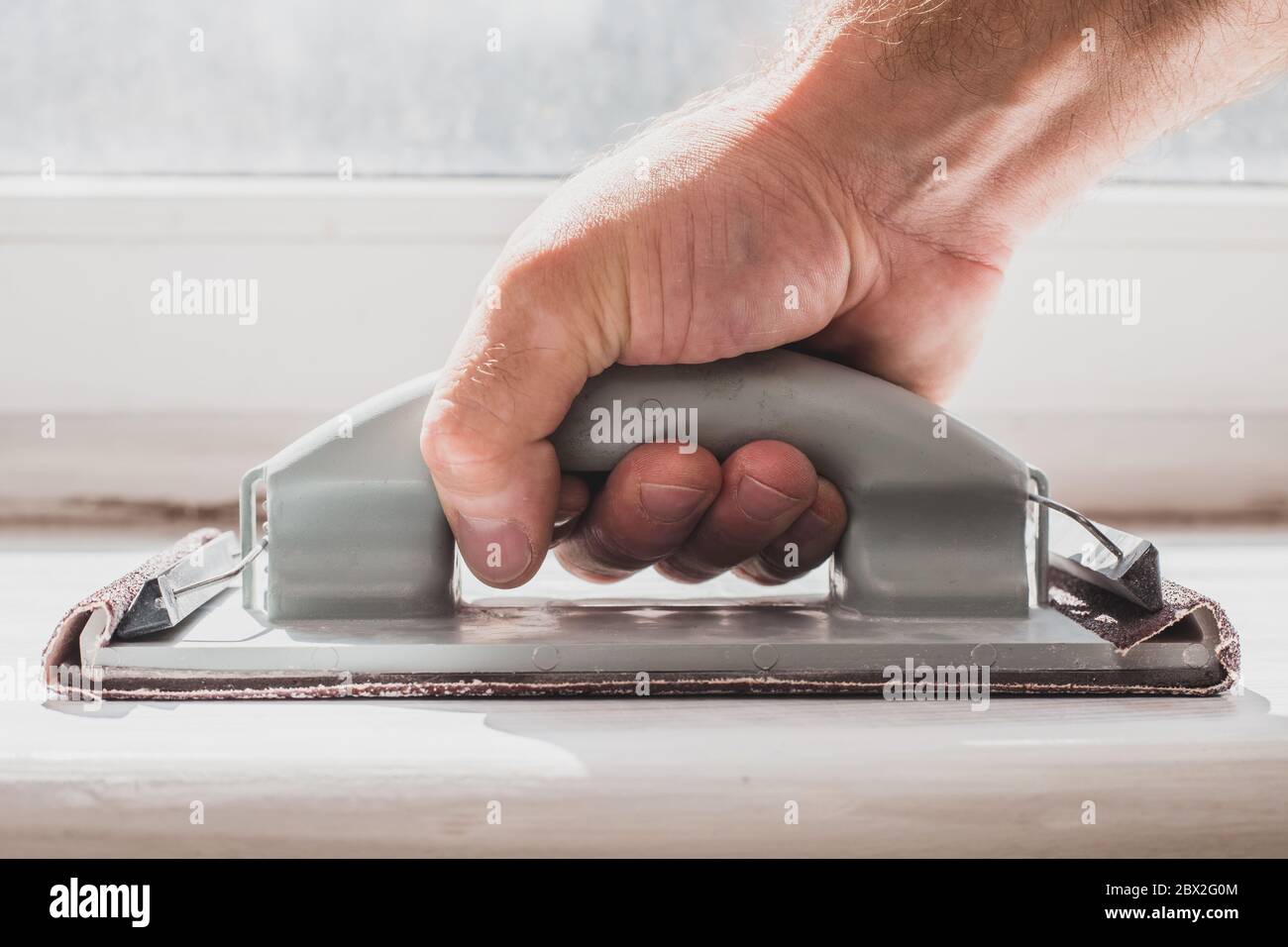 Leveling the surface with sandpaper removing old paint and dirt layer