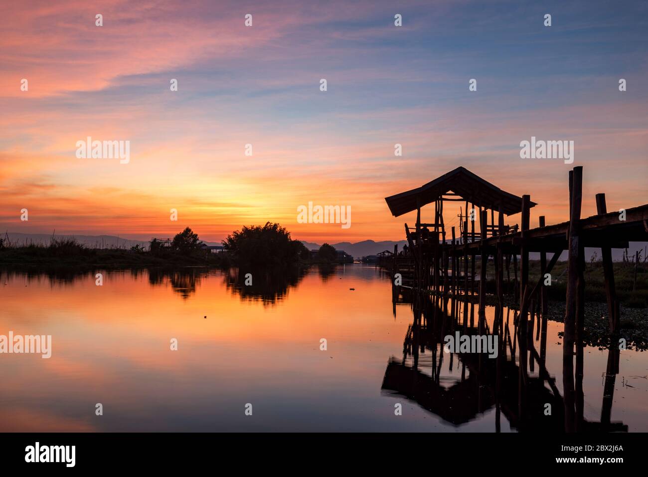 Sunset at the Maing Thouk Wooden Bridge, Inle Lake, Myanmar Stock Photo