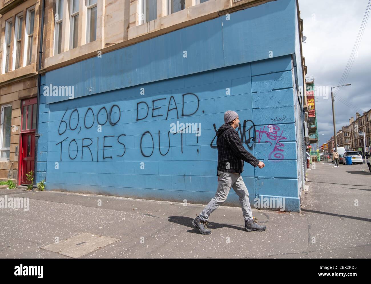 Glasgow, Scotland, UK. 4th June, 2020. Graffiti writing on a wall in Govanhill saying 60,000 Dead. Tories Out! Credit: Skully/Alamy Live News Stock Photo