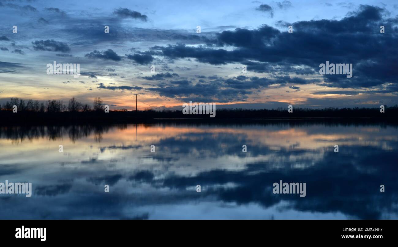 Beautiful evening landscape with reflection of clouds in a lake Stock Photo