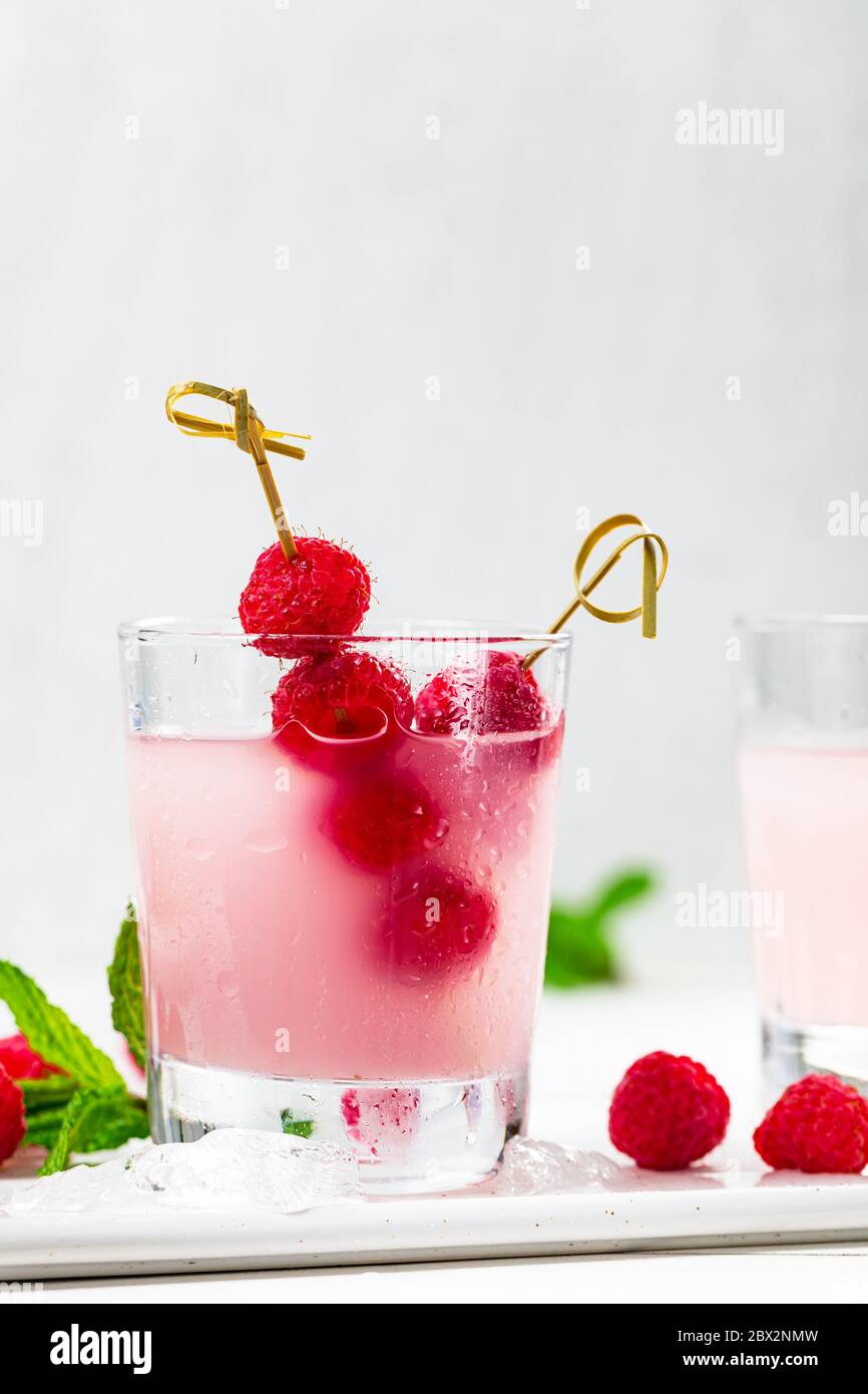 Raspberry Vodka Shots Lemonade Cocktail with Fresh Raspberry on White Wooden Background. Stock Photo
