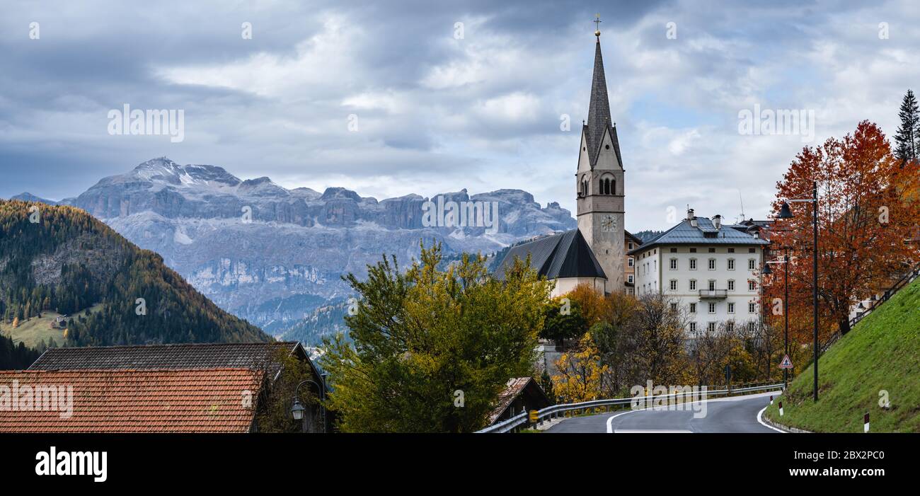 Autumn alpine Dolomites scene, Sudtirol, Italy. Peaceful village and old church view from road, Localita Soraru, Livinallongo del Col di Lana, Belluno Stock Photo