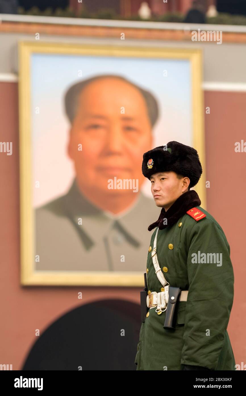 China, Beijing municipality, Beijing City, Forbidden City, listed as World Heritage by UNESCO, main entrance, tight shot of a young soldier standing guard in front of a giant portrait of Mao Zedong Stock Photo