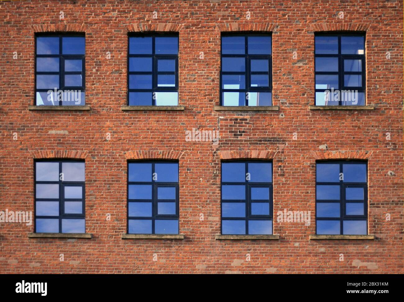 Black factory/warehouse windows, part of a old brick facade building elevation Stock Photo