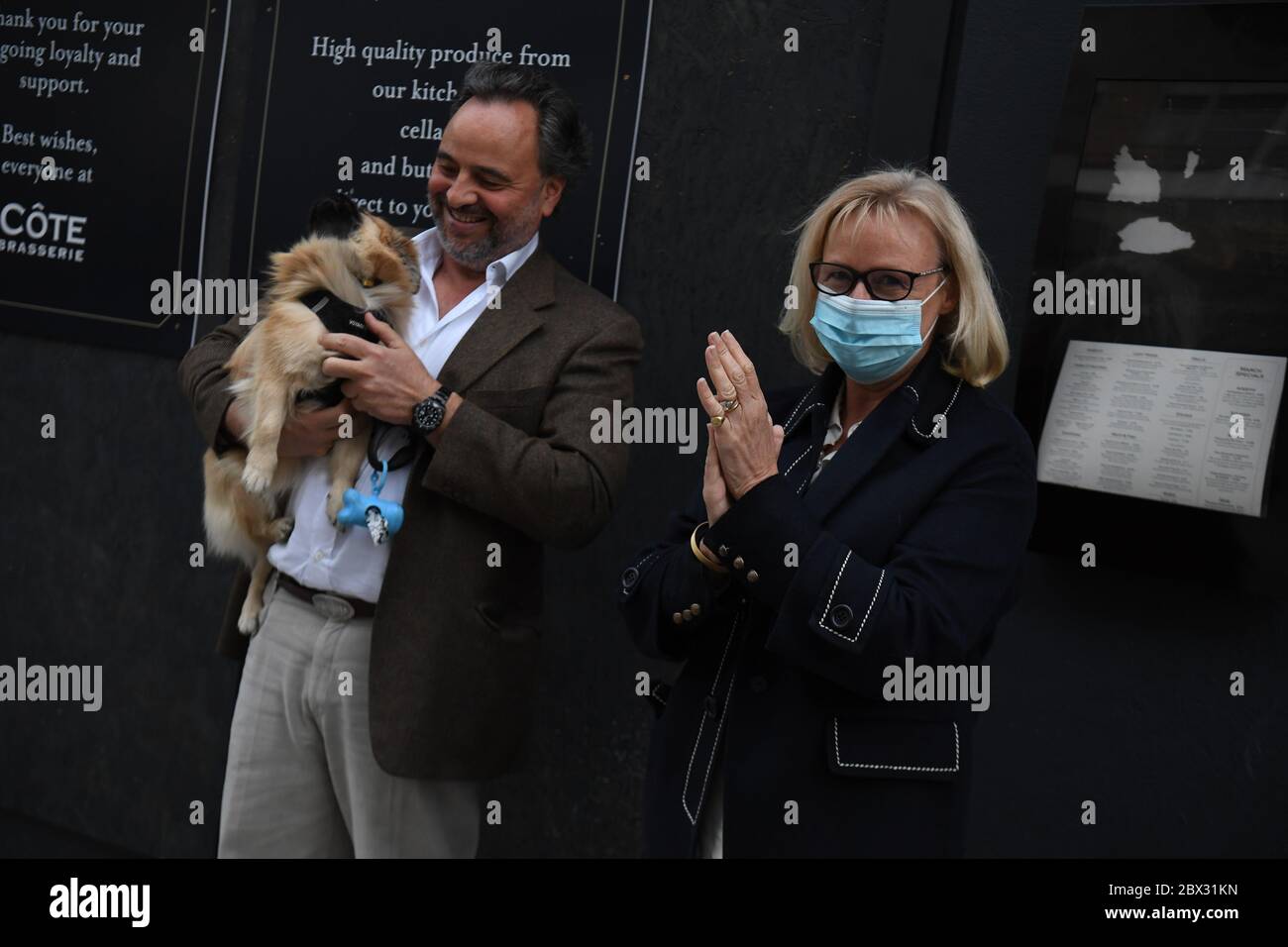 A couple outside the Chelsea and Westminster Hospital, London, join in applause during a Clap for Carers to recognise and support NHS workers and carers fighting the coronavirus pandemic. Stock Photo