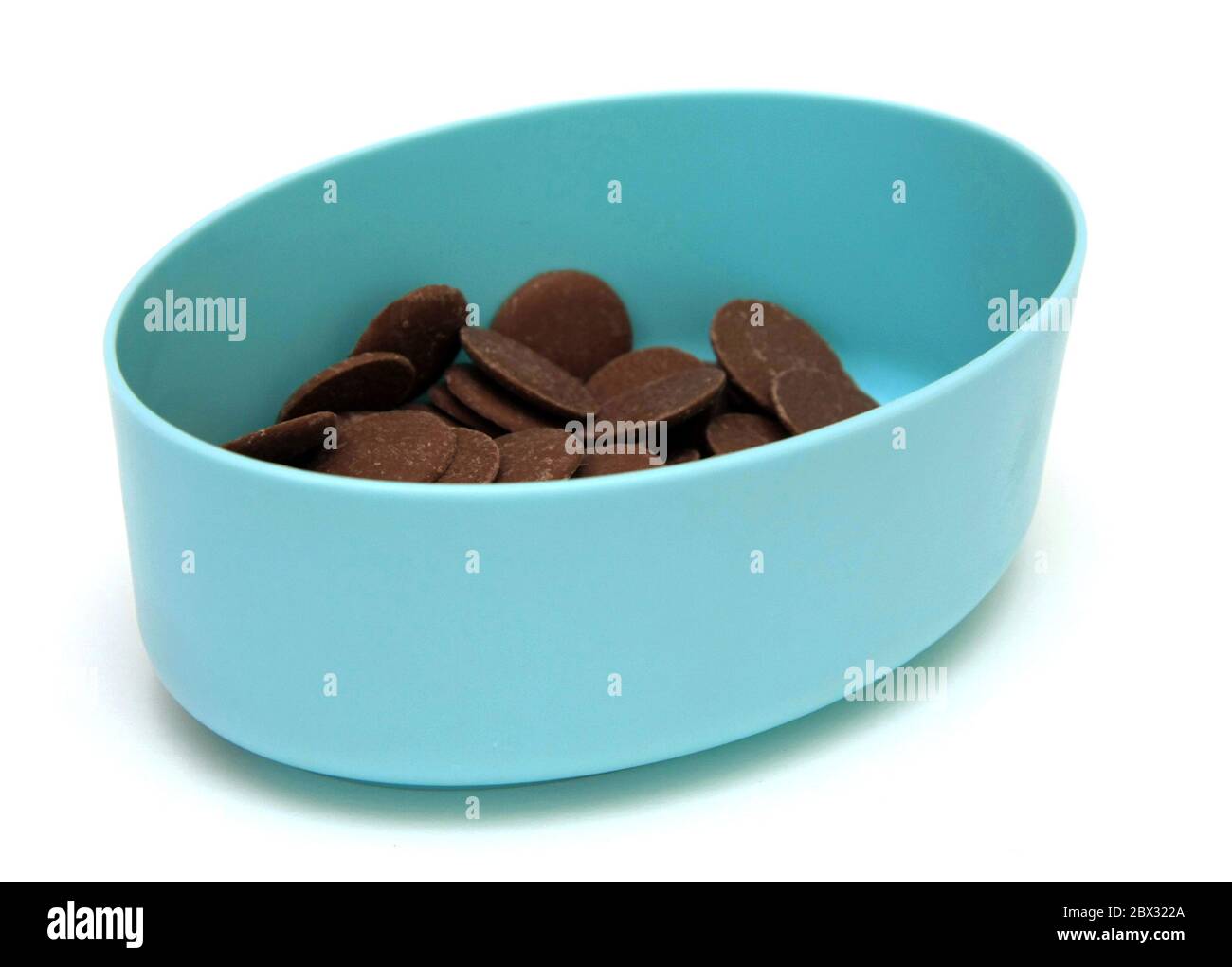 Milk Chocolate Buttons in a blue container on a white background Stock ...