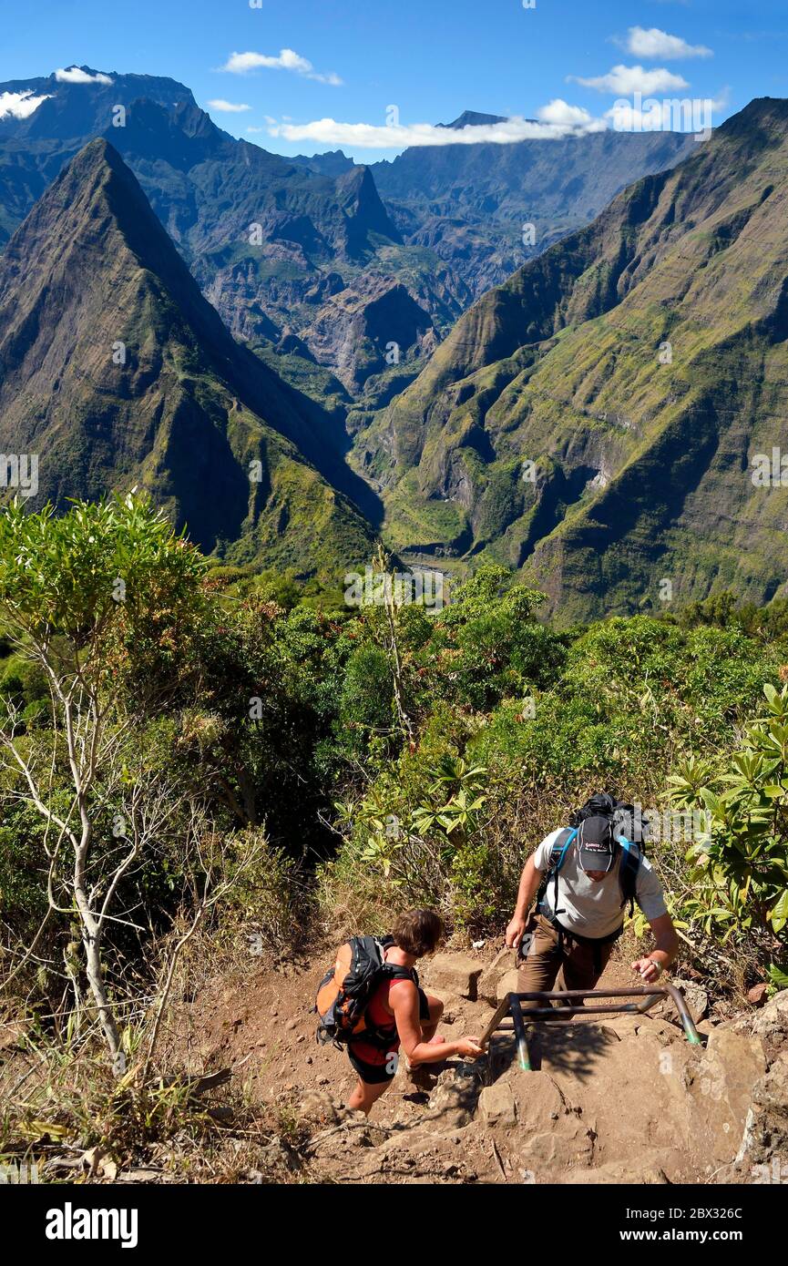 France, Reunion island (French overseas department), Reunion National Park listed as World heritage by UNESCO, La Possession, around village of Dos d'Ane, Roche Bouteille hike, hikers on a ladder of the Cap Noir trail and the Cirque de Mafate Stock Photo