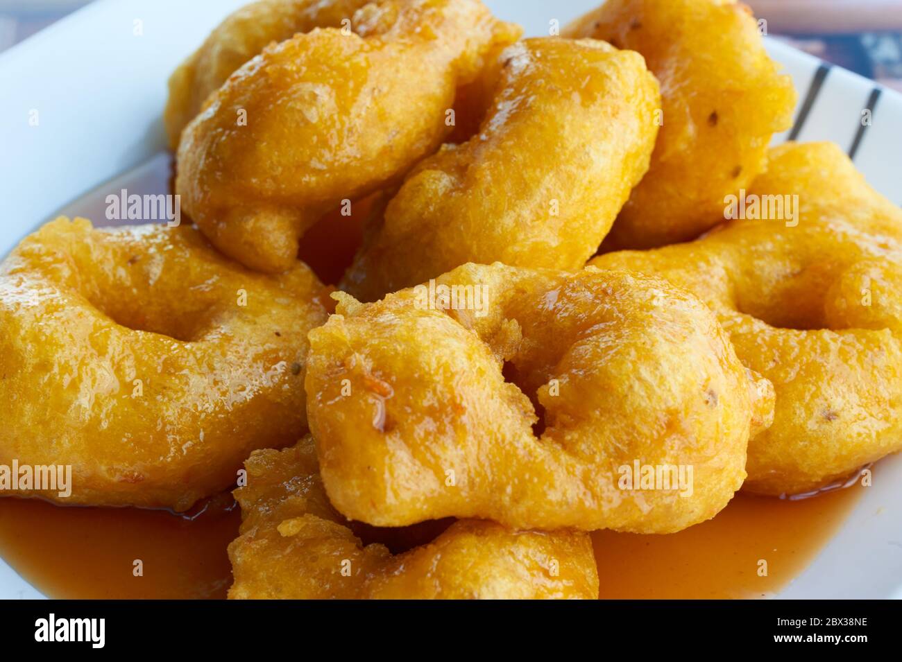 Picarones: These are ring-shaped dessert made with wheat flour dough mixed with pumpkin and sweet potato. fried and dipped in fig molasses. Stock Photo
