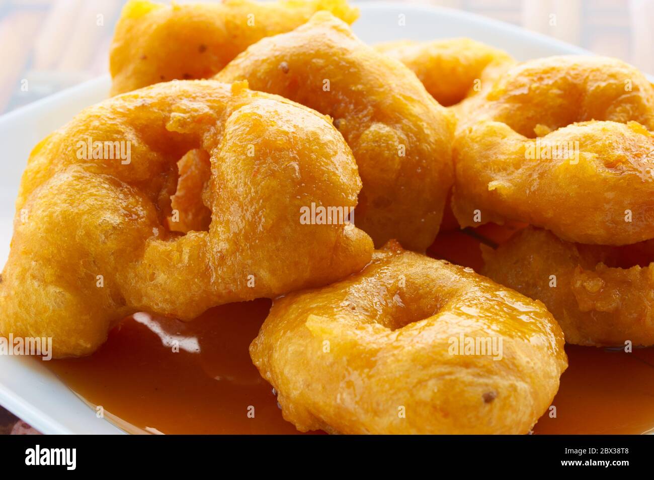 Picarones: These are ring-shaped dessert made with wheat flour dough mixed with pumpkin and sweet potato. fried and dipped in fig molasses. Stock Photo