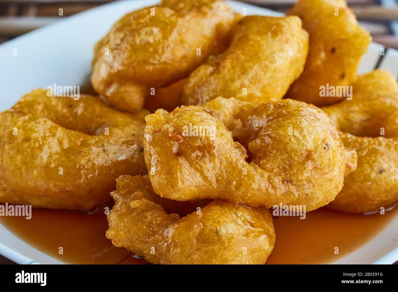 Picarones: These are ring-shaped dessert made with wheat flour dough mixed with pumpkin and sweet potato. fried and dipped in fig molasses. Stock Photo