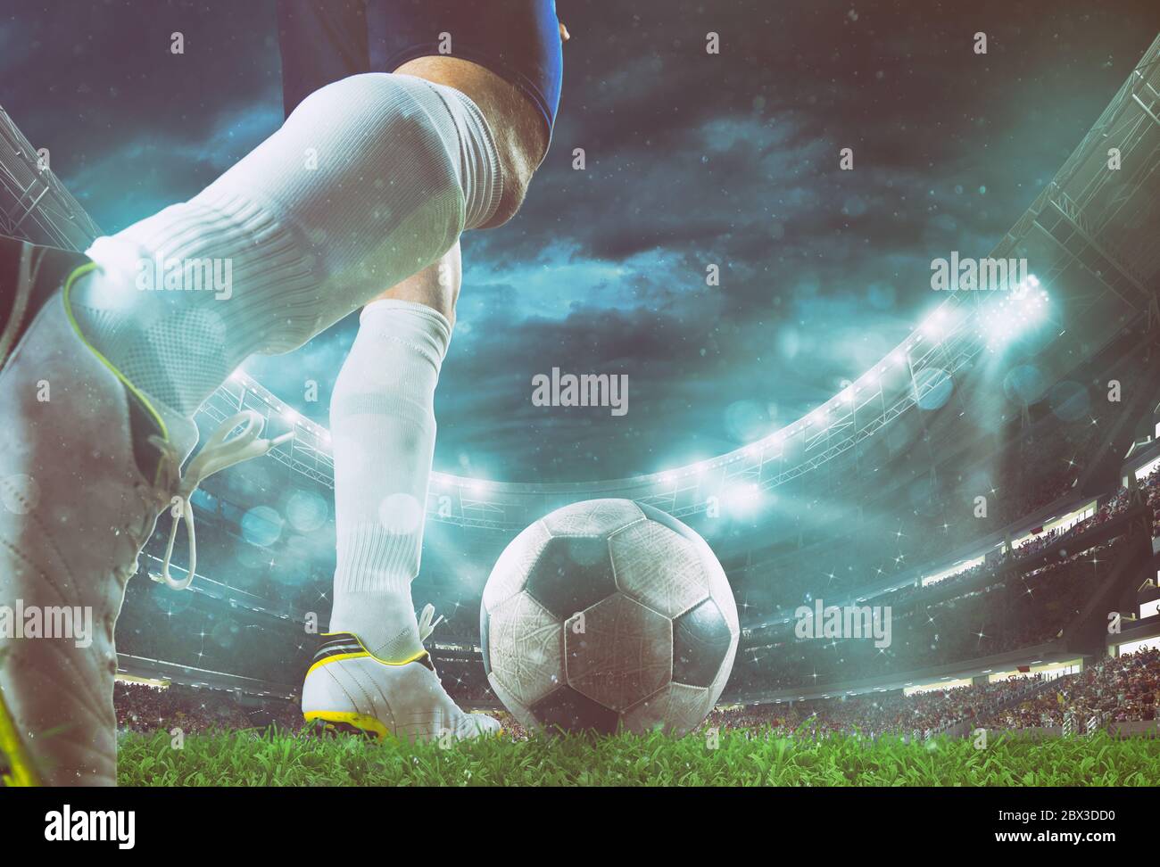 Close up perspective of a soccer scene at night match with player kicking the ball Stock Photo