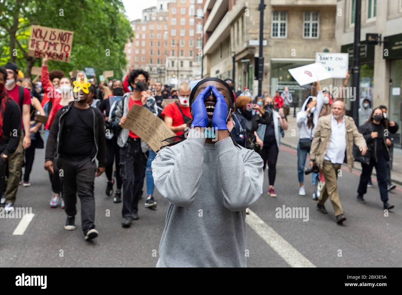 A protester cupping his gloved hands and shouting at the Black Lives Matters protest in London, 3 June 2020 Stock Photo