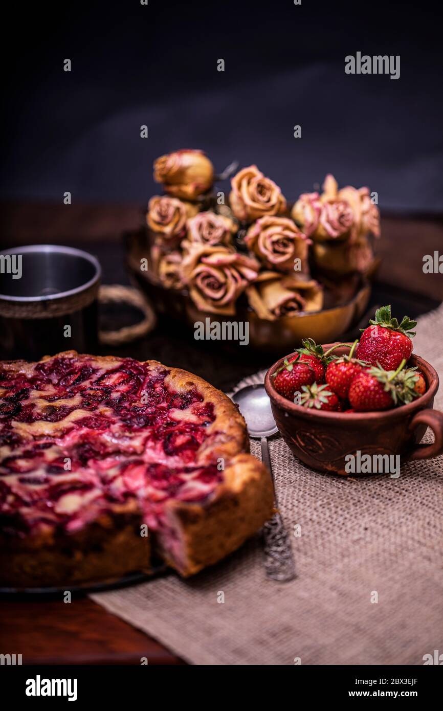 Traditional homemade strawberry cake dessert with fresh strawberry on vintage wooden background. Dark food photo, rustic style, natural light. Stock Photo