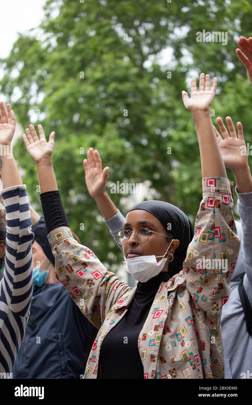 A young ethnic girl taking the knee and raising her hands during the Black Lives Matters protest outside 10 Downing Street, London, 3 June 2020 Stock Photo