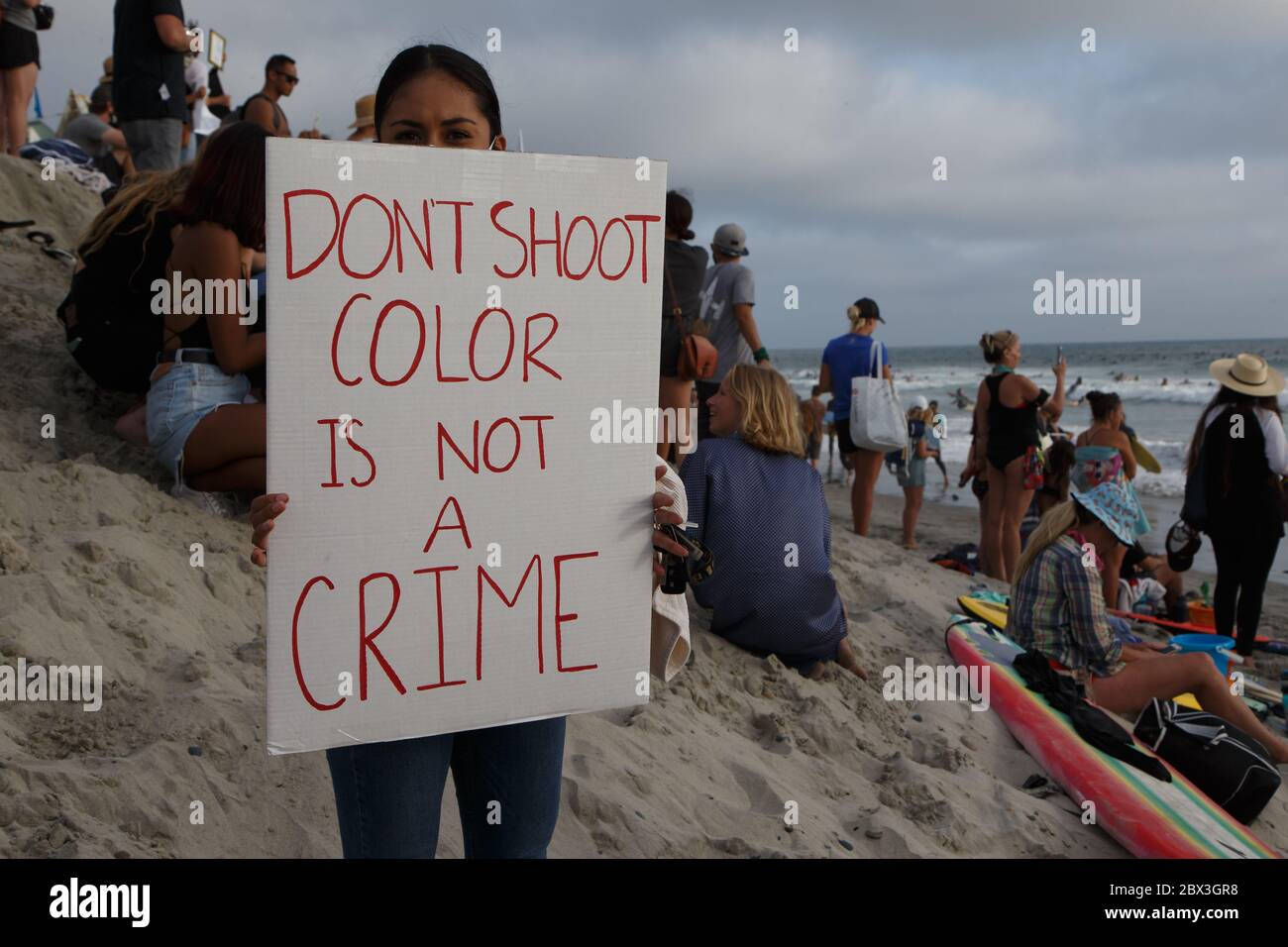 A girl holds a sign that reads 'Don't Shoot, Color is not a Crime' at an Encinitas, CA George Floyd memorial. Stock Photo