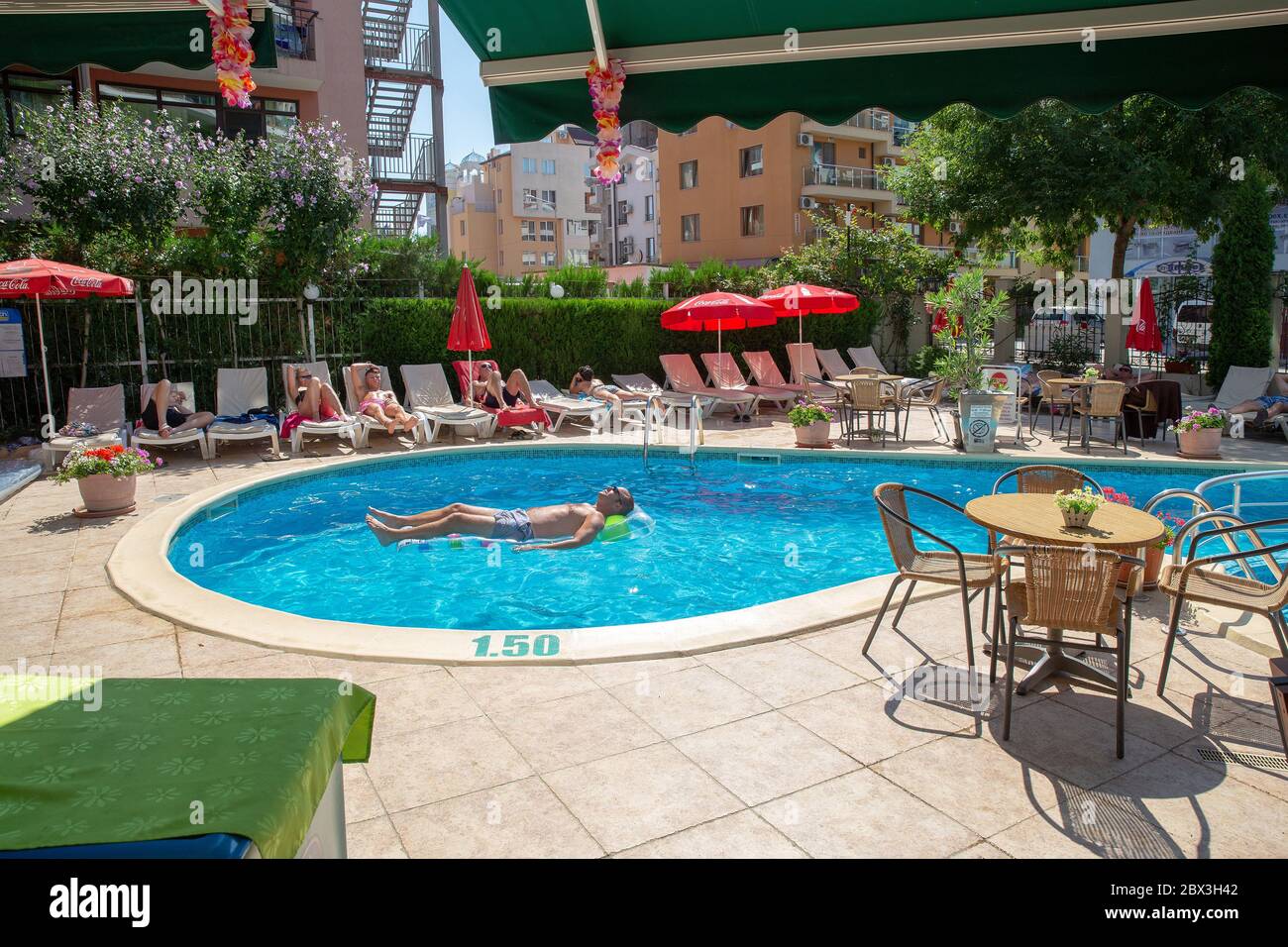 08/05/2018  Burgas and Sunny beach in  Bulgaria . Man on bathing mattress in small p[ool near hotel in Bulgaria  and people  on  deck chairs Stock Photo