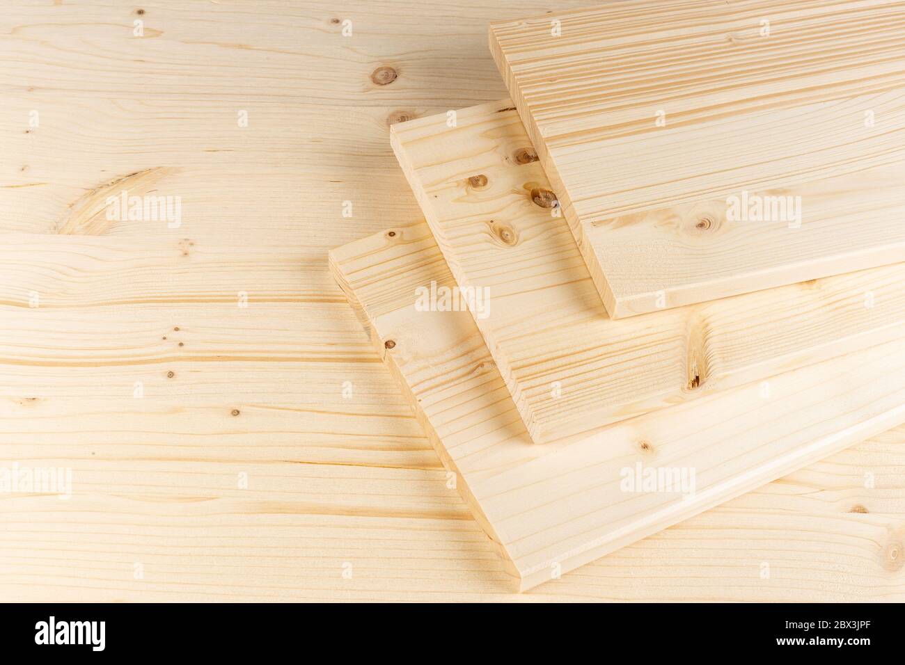 stack of spruce wood construction planks or boards on wooden background. Natural material carpentry diy industry furniture making concept. Stock Photo