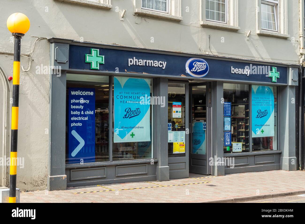 Boots Pharmacy with Covid-19 information posters in window in Bandon, West Cork, Ireland Stock Photo