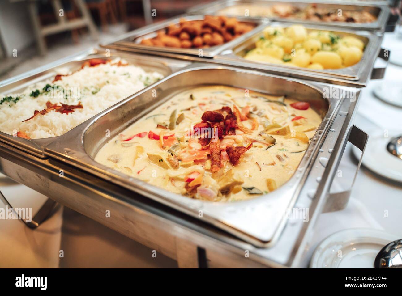 Stainless hotel pans on food warmers with various meals. Roasted meat  pieces with vegetable. Self-service buffet table. Celebration, party,  wedding Stock Photo - Alamy