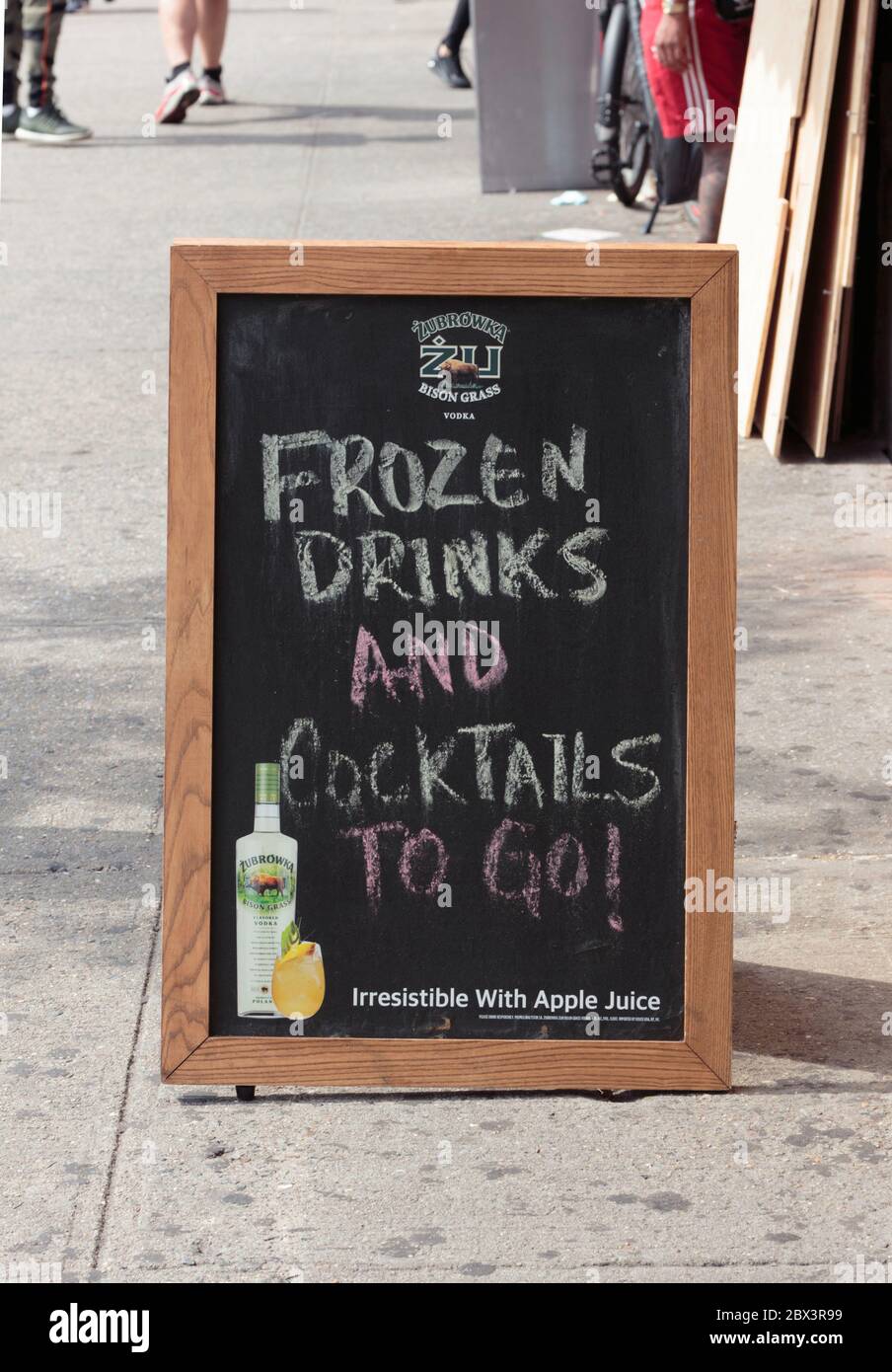 sidewalk blackboard or chalkboard sign advertising cocktails to go due to ongoing coronavirus or covid-19 restrictions Stock Photo