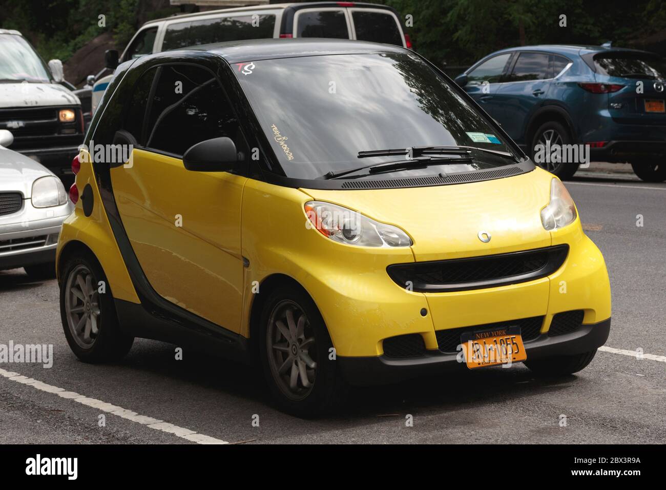 a bright yellow Smartcar parked on a street in nyc, a rare sight as Daimler AG stopped selling them in the US in 2019 Stock Photo