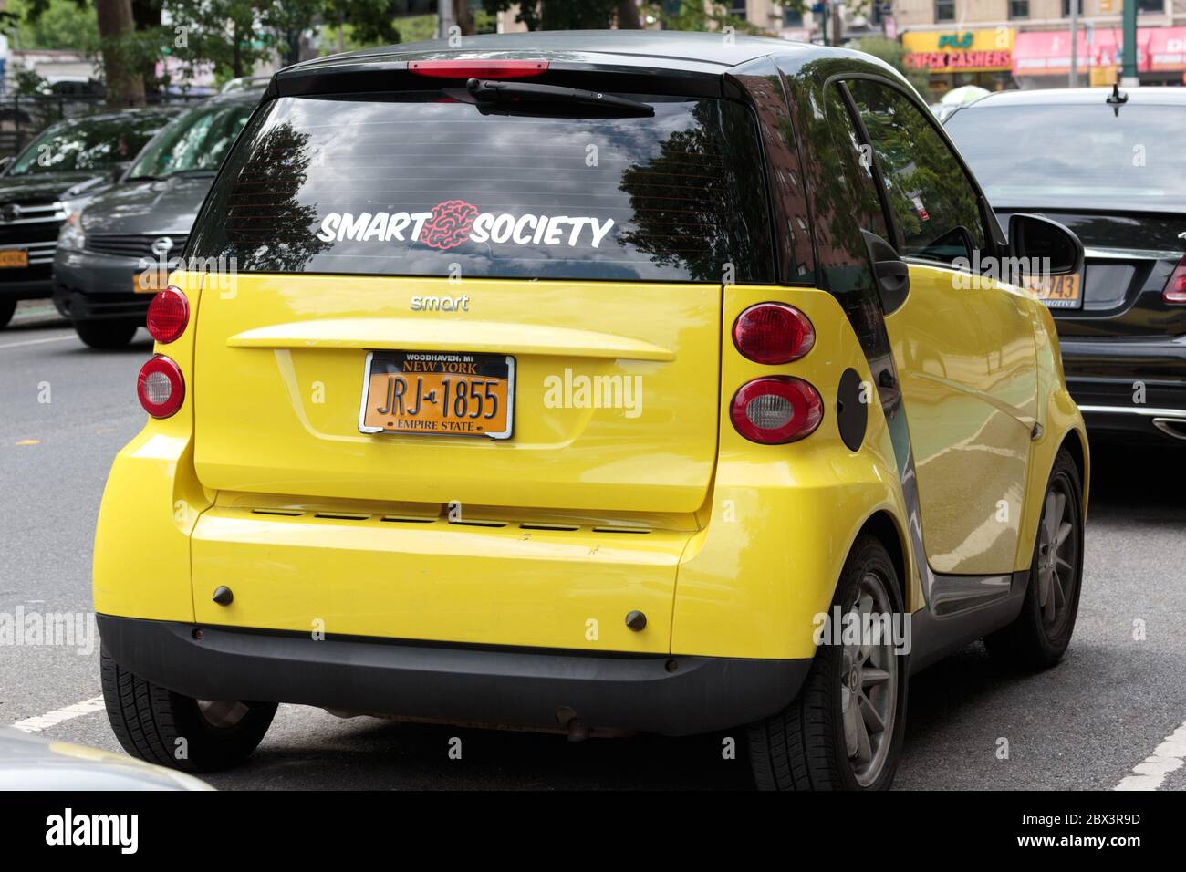 a bright yellow Smartcar parked on a street in nyc, a rare sight as Daimler AG stopped selling them in the US in 2019 Stock Photo