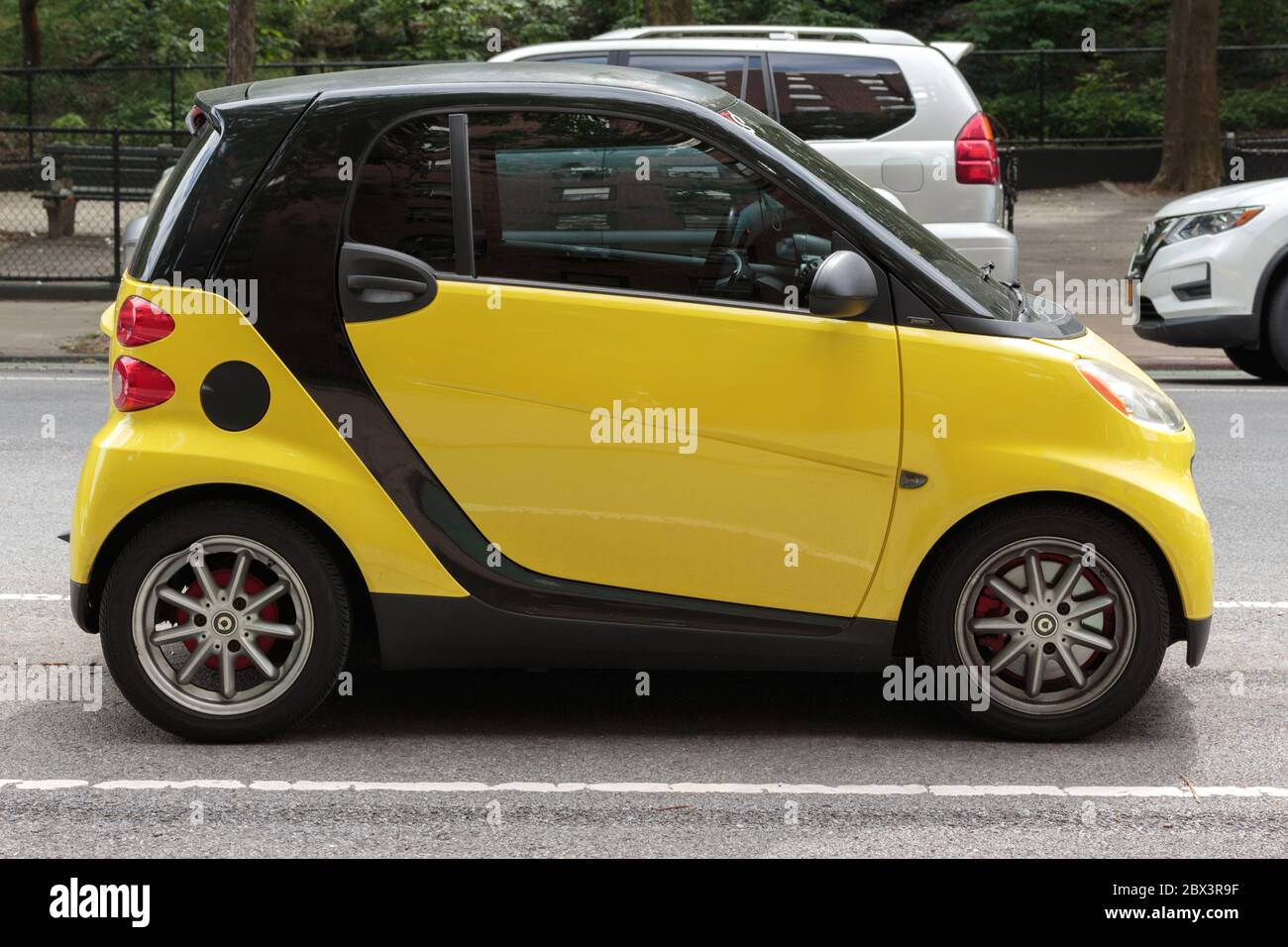 a bright yellow Smartcar parked on a street in nyc, a rare sight as Daimler AG stopped selling them in the US in 2019 Stock Photo