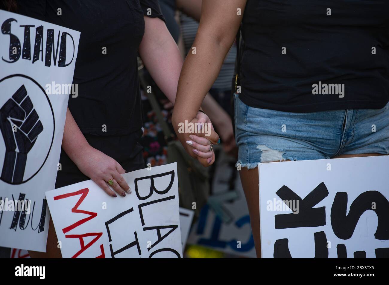 Manhattan, Kansas, USA. 3rd June, 2020. ANNIE MCBEE, left, holds during an emotional speech by Taneika Nicole during a peaceful protest in City Park on Wednesday. The protest was organized in response to the death of George Floyd by Minneapolis police last week. Credit: Luke Townsend/ZUMA Wire/Alamy Live News Stock Photo