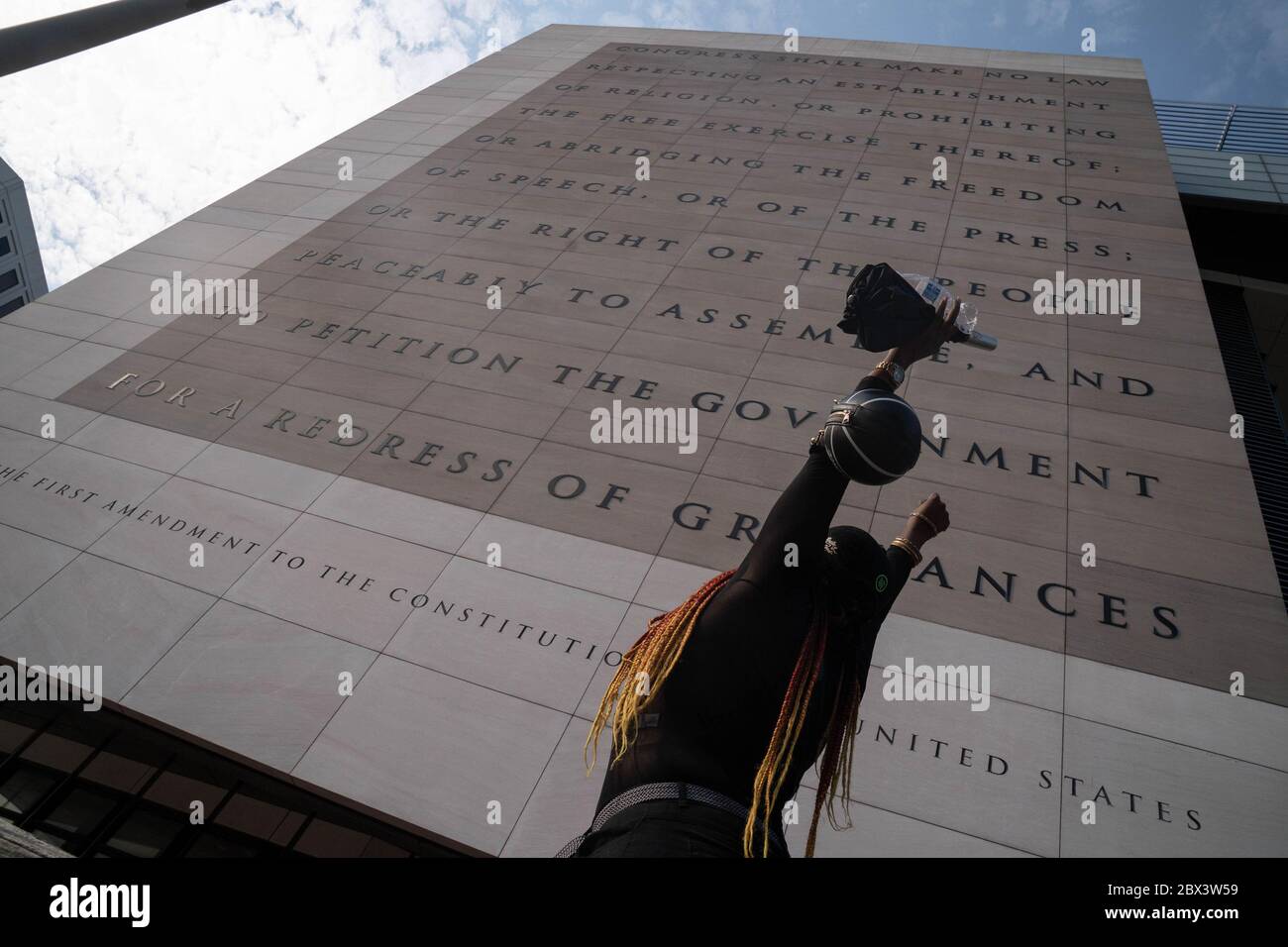 Washington, United States. 04th June, 2020. A protester raises her arms as she walks by the old Newseum where the First Amendment to the Constitution is displayed during demonstrations against police brutality and the death of George Floyd on Thursday June 4, 2020 in Washington, DC. Demonstrations continue around the country over the death of George Floyd who was killed in police custody in Minneapolis on May 25. Photo by Ken Cedeno/UPI Credit: UPI/Alamy Live News Stock Photo