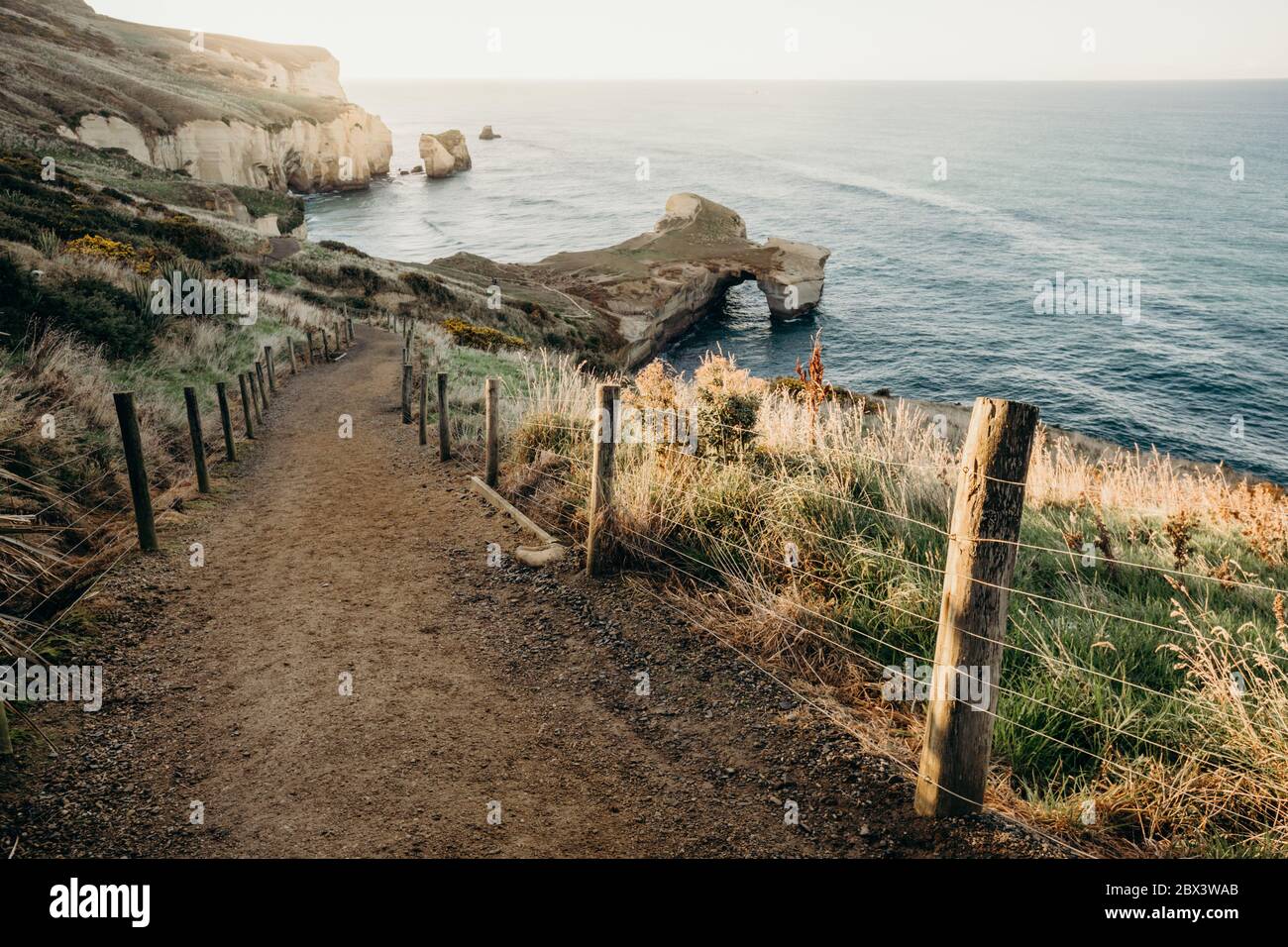Beautiful sunrise with Natural arch at Tunnel beach, Otago Peninsula, New Zealand Stock Photo
