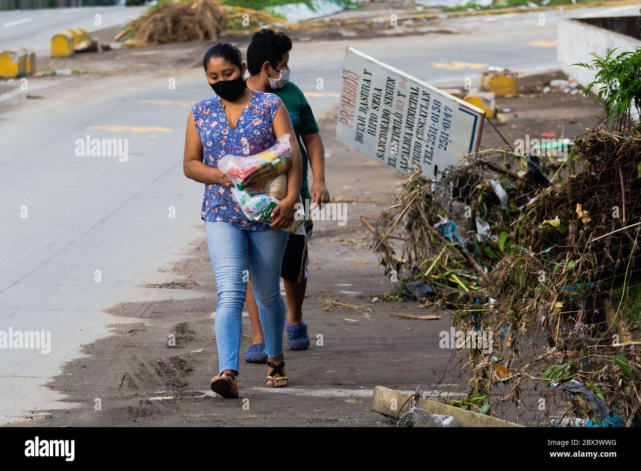 Antiguo Cuscatlan, La Libertad, El Salvador. 4th June, 2020. Two people carrying food to one side of La Cuchilla Community. This is one of several communities at risk due to storms in El Salvador that has caused floods and landslides since last Sunday, May 31. Credit: Carlos Diaz/Alamy Live News Stock Photo