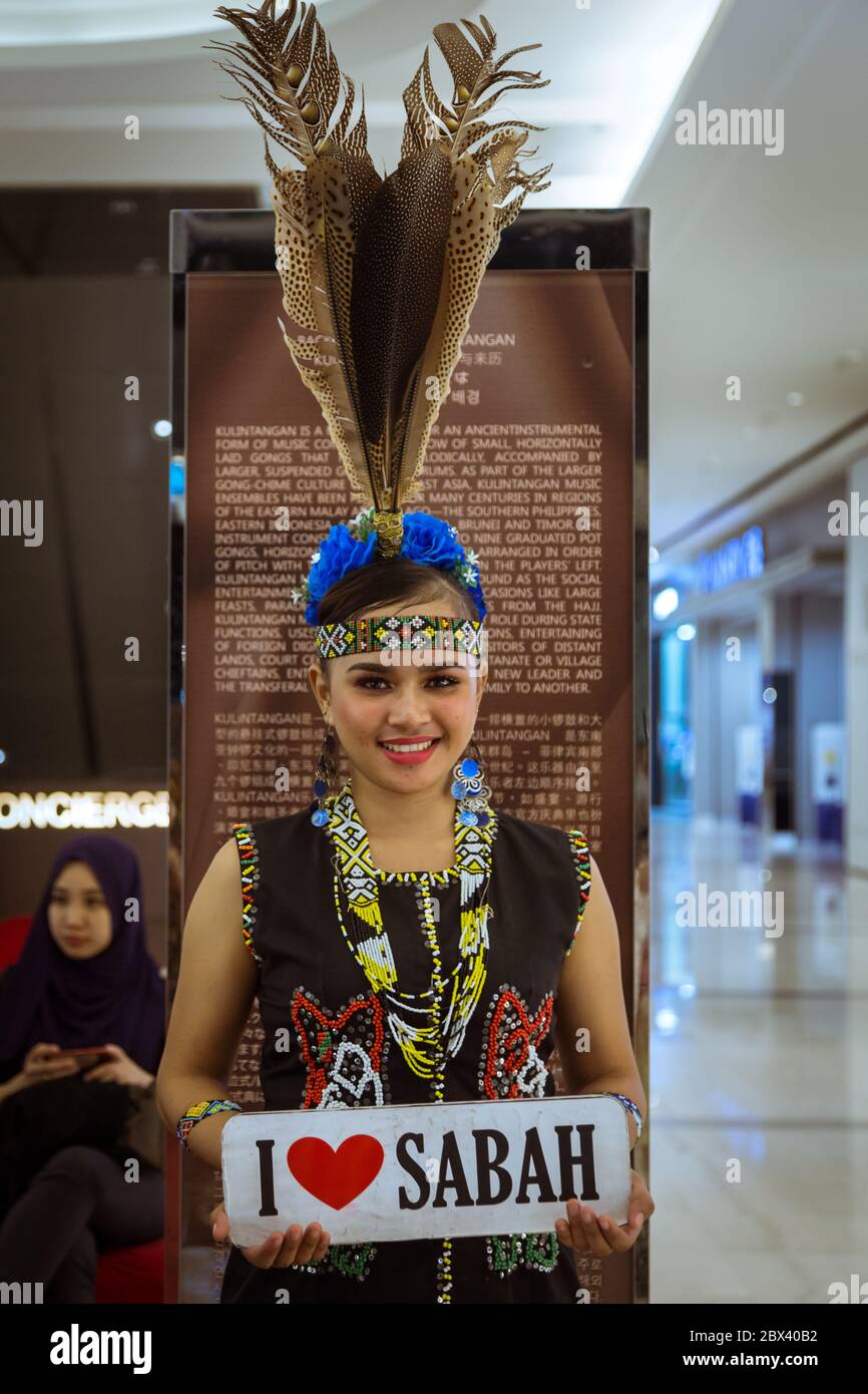 Kota Kinabalu, Sabah , Malaysia - May 22, 2017 : A pretty Murut lady in traditional costume and holding I LOVE SABAH sign, Murut is among the largest Stock Photo