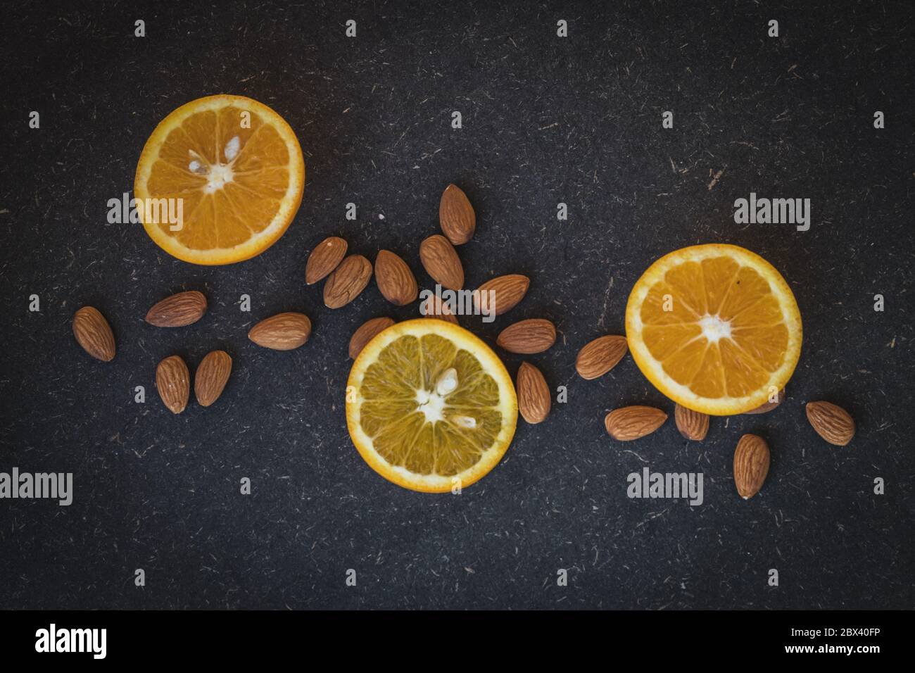 Oranges and almonds in a dark background Stock Photo