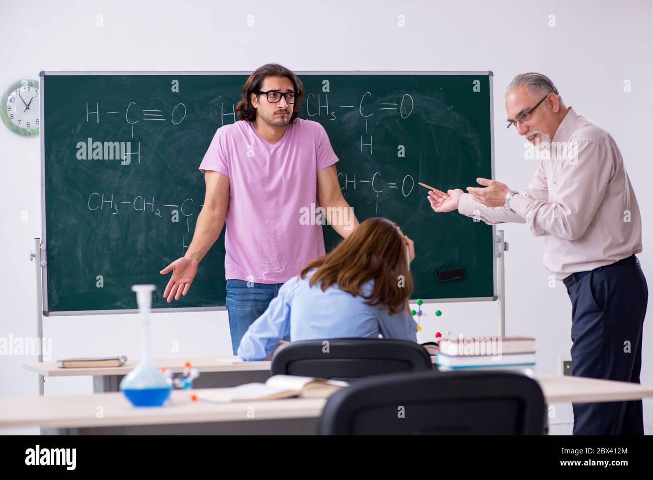Old teacher and two students in the classroom Stock Photo - Alamy