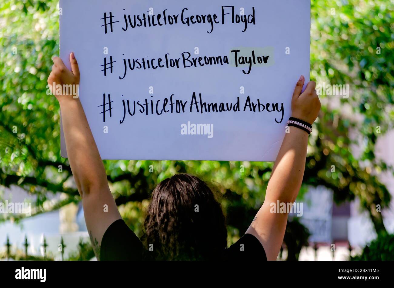 A protestor holds up a sign while at a protest against police brutality, June 4, 2020, at Memorial Park in Mobile, Alabama. Stock Photo
