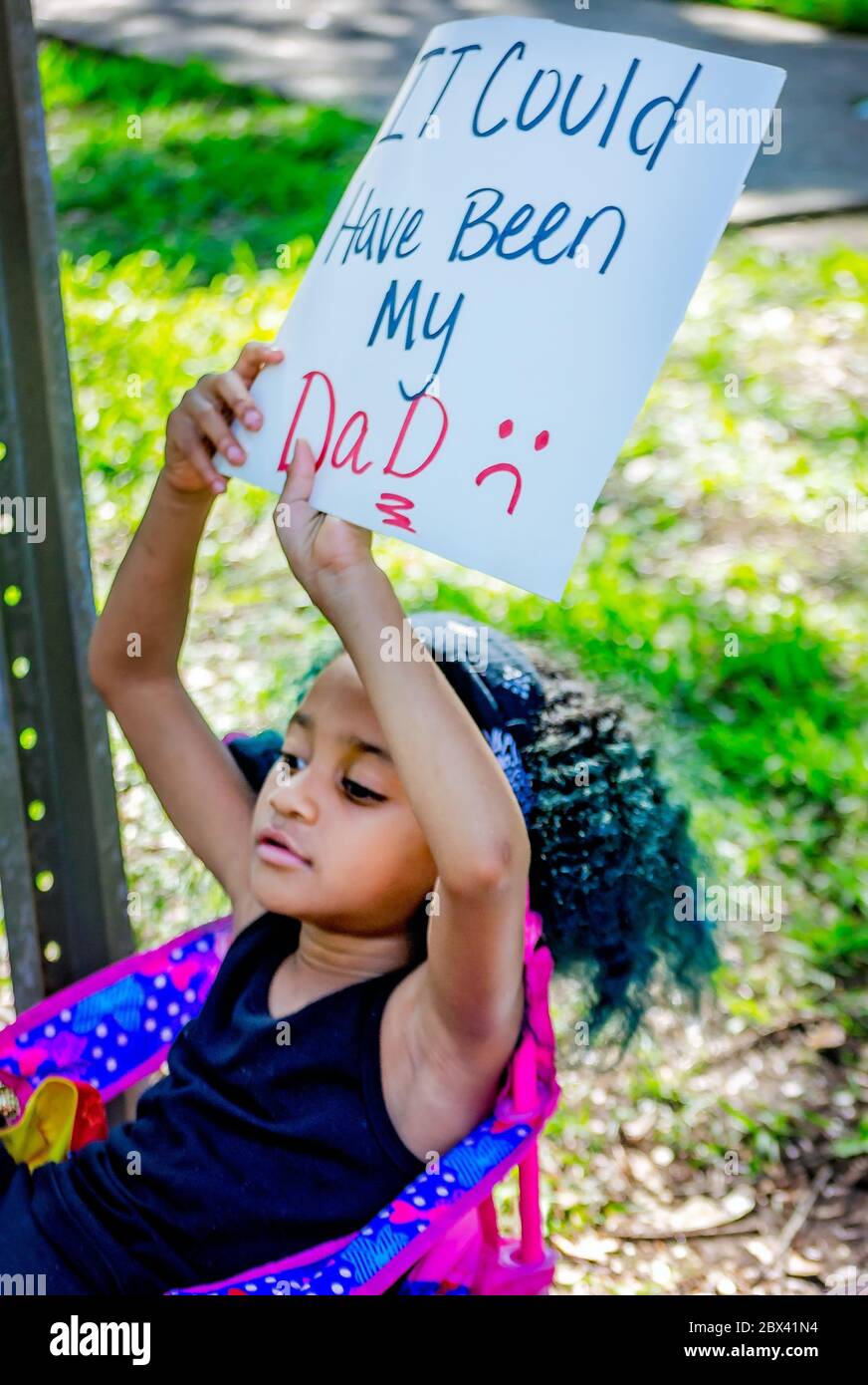 A young African-American girl holds a sign while at a protest against police brutality, June 4, 2020, at Memorial Park in Mobile, Alabama. Stock Photo