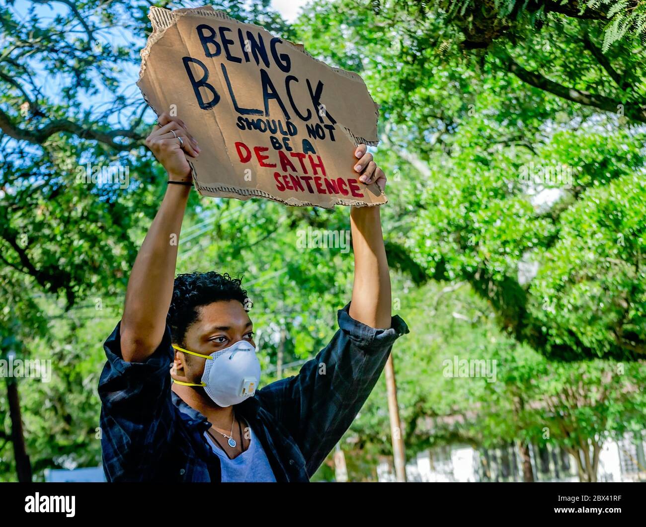 A protestor holds up a sign while at a protest against police brutality, June 4, 2020, at Memorial Park in Mobile, Alabama. Stock Photo