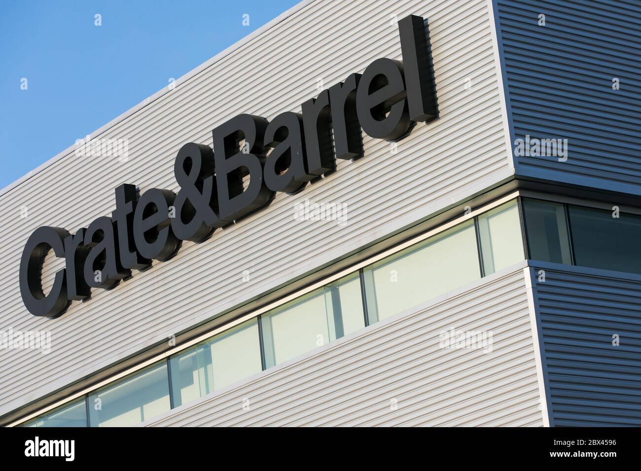 A logo sign outside of a Crate and Barrel retail store location in