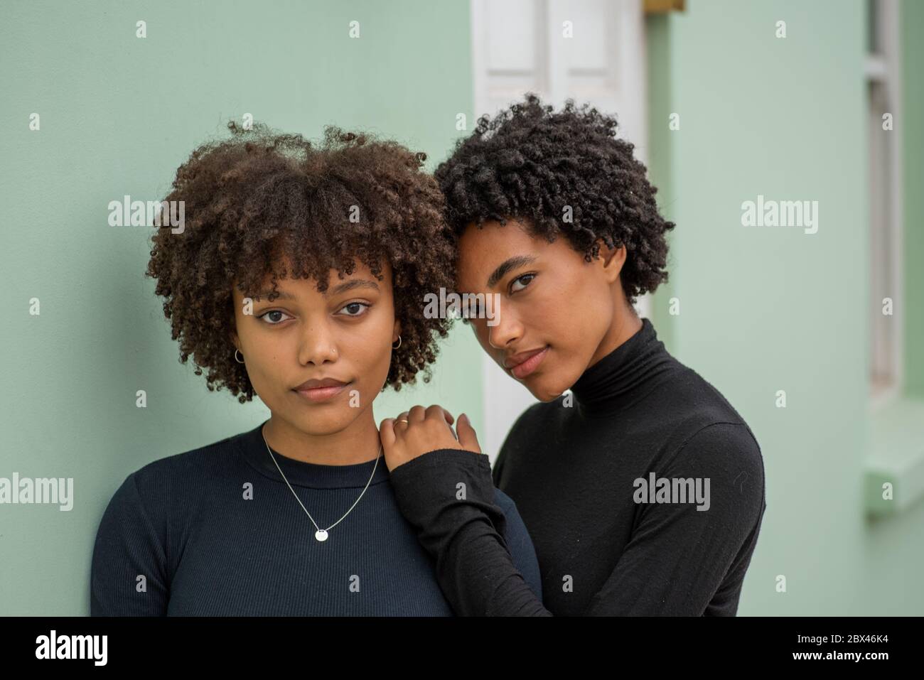 Portrait of two stylish sisters with curly hair.  Stock Photo