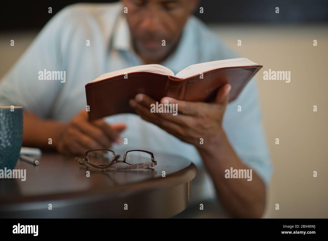 African American man praying and reading the Bible. Stock Photo