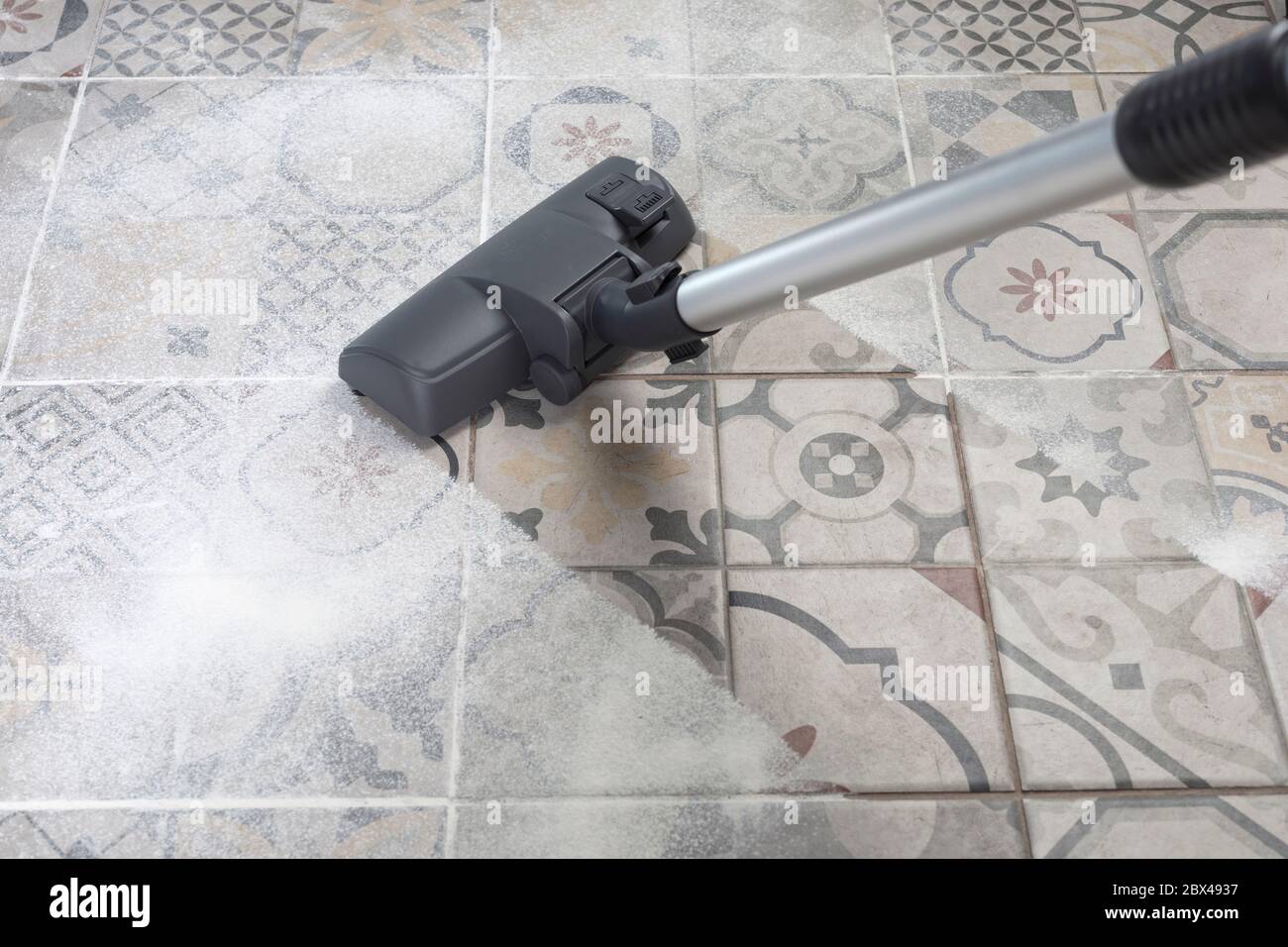 Vacuum cleaner on porcelain stoneware floor with copyspace for text