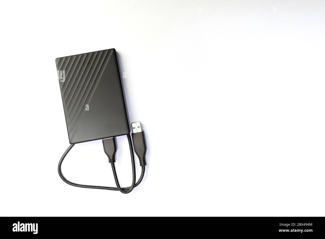 External compact SSD-drive with USB cable for writing, reading and storing data. on white background, top view Stock Photo