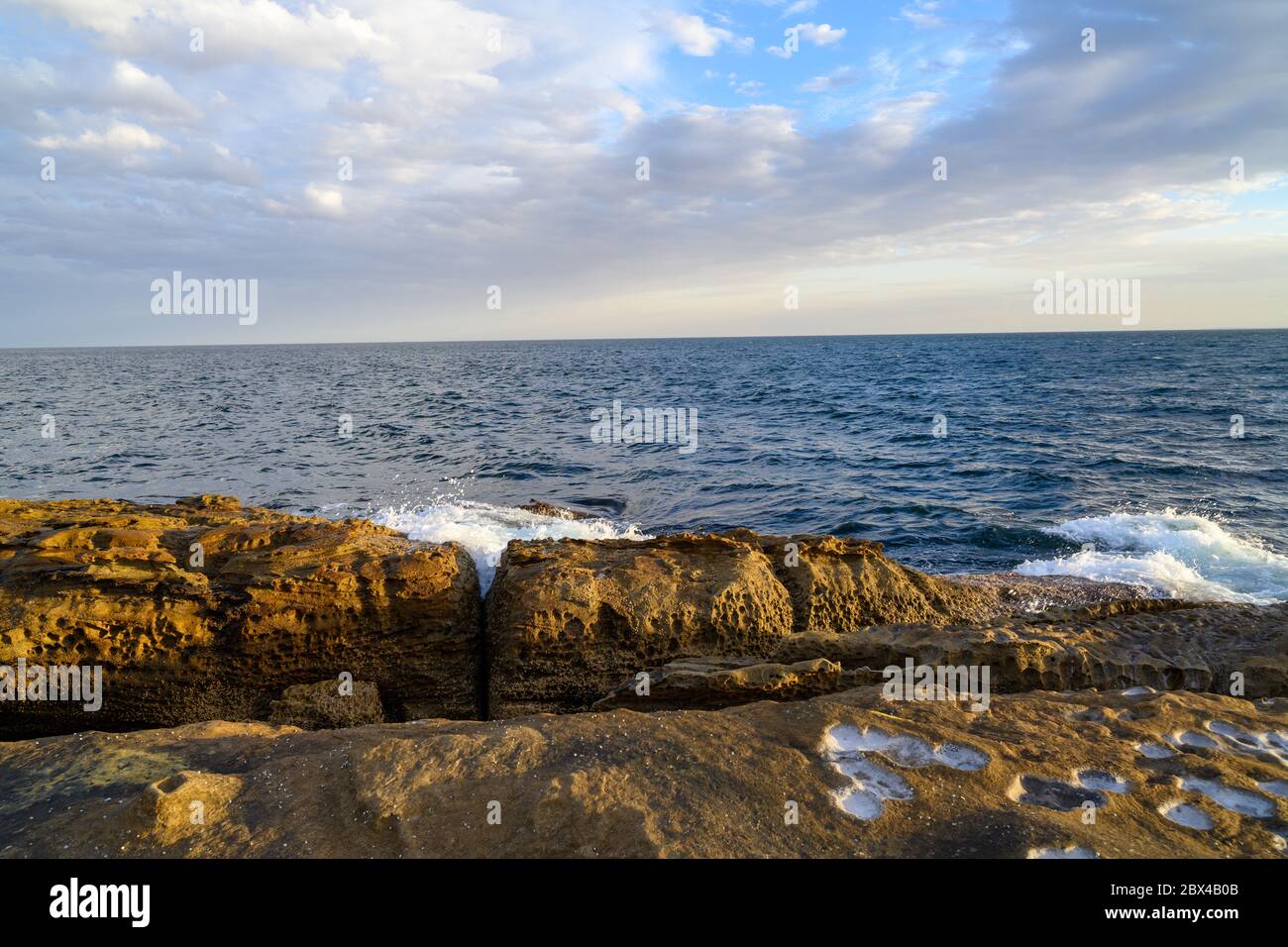 Waves crashing against a rock platform Stock Photo