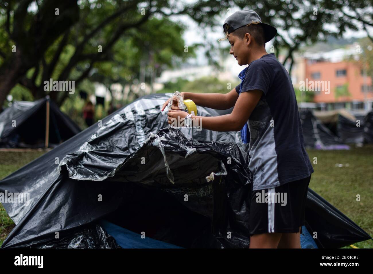 Stranded Venezuelans build makeshift camp in a tree-covered park amid Covid-19 pandemic, waiting for an opportunity to return to their country, Cali, Stock Photo